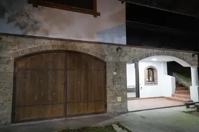 a large wooden garage door on a stone wall at Apartman Centar 18 in Ub