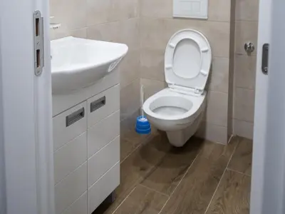 a bathroom with a white toilet and a sink at Apartman Centar 18 in Ub