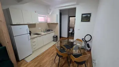 a kitchen with a glass table and a refrigerator at Apartman Lela in Belgrade