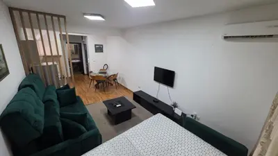 a living room with a green couch and a television at Apartman Lela in Belgrade