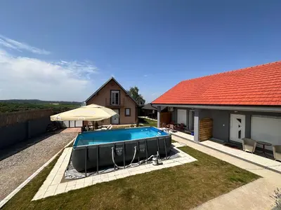 a swimming pool in a yard next to a house at Villa Popovic - apartments Fruska gora in Sremski Karlovci