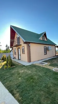 a house with a green roof and a grass yard at Villa Popovic - apartments Fruska gora in Sremski Karlovci