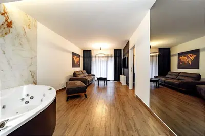 a bathroom with a tub and a living room at Dark Nest 2 Belgrade Apartments in Belgrade