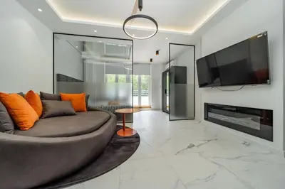 a living room with a grey couch and a tv at Zebrano Spa in Novi Beograd