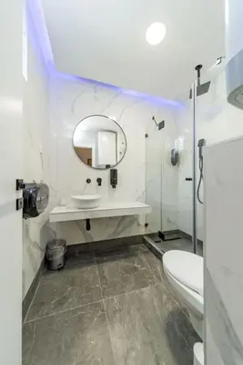 a bathroom with a sink and a toilet and a mirror at Zebrano Spa in Novi Beograd