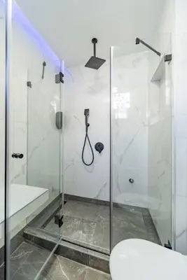 a bathroom with a glass shower with a toilet at Zebrano Spa in Novi Beograd