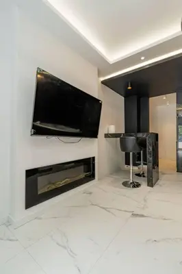 a living room with a television and a fireplace at Zebrano Spa in Novi Beograd