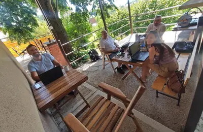 a group of people sitting at a table with laptops at Kućica Osmeha in Donja Ralja