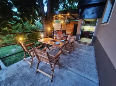 a wooden table and chairs on a patio at Kućica Osmeha in Donja Ralja