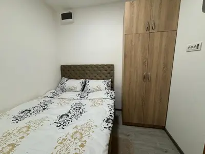 a bedroom with a bed and a wooden cabinet at Apartment DD in Belgrade
