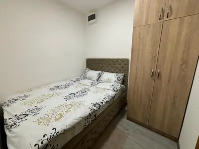 a bedroom with a bed and a wooden cabinet at Apartment DD in Belgrade