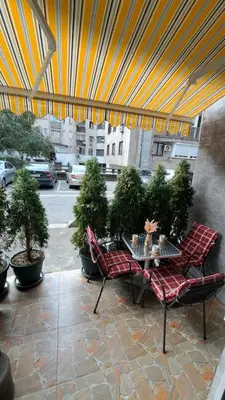 a patio with two chairs and a table and potted plants at Apartment DD in Belgrade