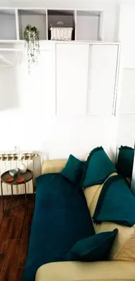 a couch with blue pillows in a living room at Cradle of Love in Belgrade