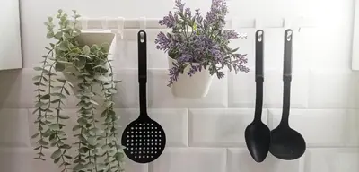 a group of utensils hanging on a wall with plants at Cradle of Love in Belgrade