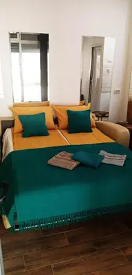 a bedroom with two beds with green and orange at Cradle of Love in Belgrade