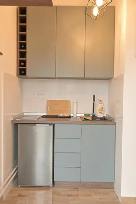 a kitchen with white cabinets and a counter top at MUNJA Apartman in Belgrade