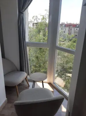 a room with a window with two chairs and a table at MUNJA Apartman in Belgrade