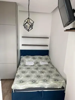 a small bedroom with a bed in the corner at MUNJA Apartman in Belgrade