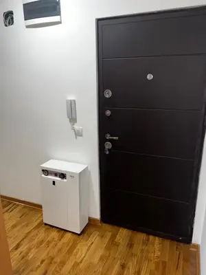 a black door in a room with a small refrigerator at Apartman Dami in Belgrade