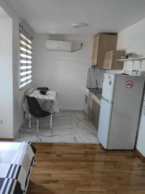 a kitchen with a white refrigerator and a table at Apartman Dami in Belgrade
