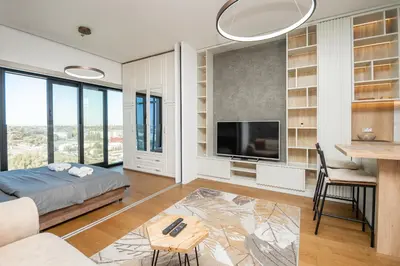 a bedroom with a bed and a table and a tv at West Kula 14 in Belgrade