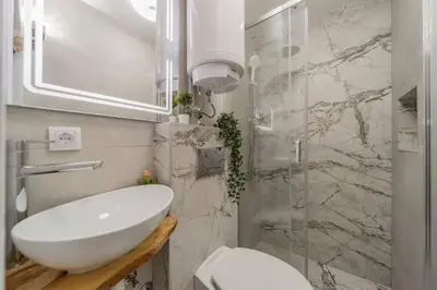 a bathroom with a sink and a glass shower at Lisa Zemun Spa Apartment in Zemun