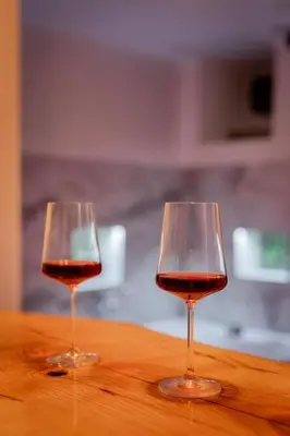 two glasses of red wine sitting on a wooden table at Lisa Zemun Spa Apartment in Zemun