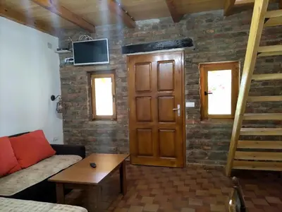 a living room with a couch and a wooden door at Tamiški mir in Staji°evo