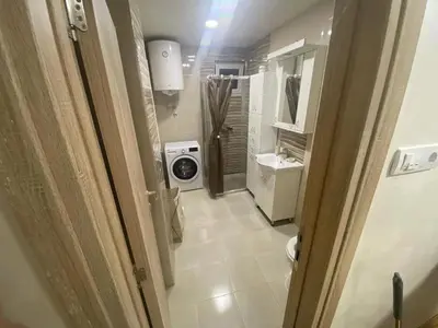 a bathroom with a sink and a washing machine at Apartment Pionir Grim in Belgrade