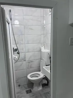 a white bathroom with a toilet and a sink at RiverScapeMoments Studio in Belgrade