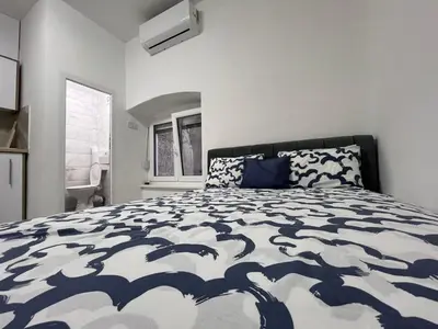 a bedroom with a bed with a blue and white comforter at RiverScapeMoments Studio in Belgrade