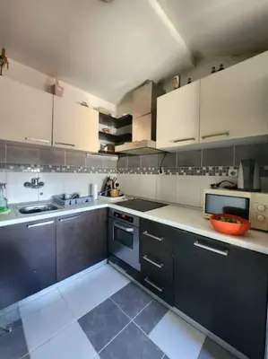 a large kitchen with white cabinets at Wenge in Karaburma