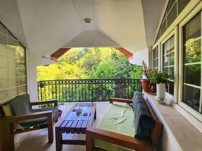 a porch with a couch and a table on a balcony at Wenge in Karaburma