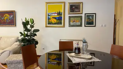 a living room with a table and paintings on the wall at Top secret 24 in Belgrade
