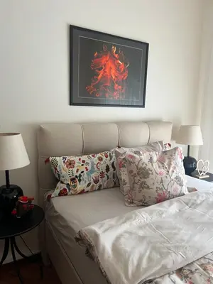 a bedroom with a bed with pillows and a picture on the wall at Top secret 24 in Belgrade