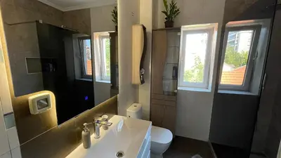 a bathroom with a sink and a toilet and a mirror at Top secret 24 in Belgrade