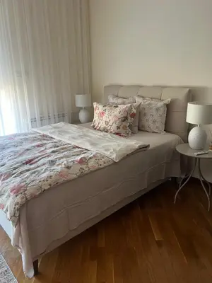 a bed in a bedroom with two tables and two lamps at Top secret 24 in Belgrade
