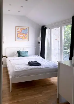 a white bed in a room with a window at Tasmajdan in Belgrade