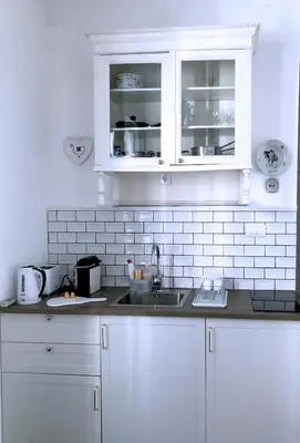 a white kitchen with a sink and white cabinets at Tasmajdan in Belgrade