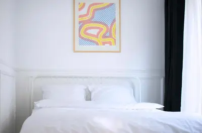 a bedroom with a white bed with a picture on the wall at Tasmajdan in Belgrade