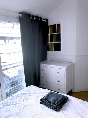 a bedroom with a bed with a dresser and a window at Tasmajdan in Belgrade
