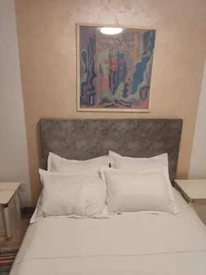 a bed with white pillows and a painting above it at Oaza lux in Dušanovac (historical)