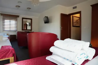 a pile of towels on a table in a hotel room at Comfort Lodge in Stari Banovci