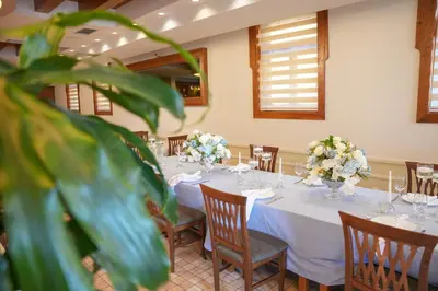 a dining room with tables and chairs with flowers at Comfort Lodge in Stari Banovci