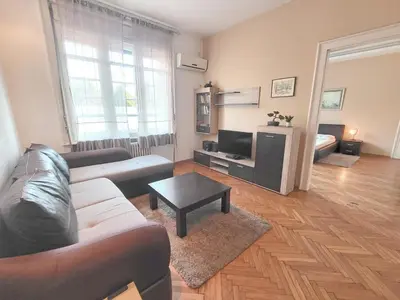 a living room with a couch and a table at Parliament City Centre PROMO PRICE in Belgrade