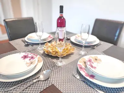 a table with plates and glasses and a bottle of wine at Parliament City Centre PROMO PRICE in Belgrade