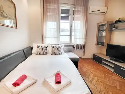 a living room with a large bed with red socks on it at Parliament City Centre PROMO PRICE in Belgrade