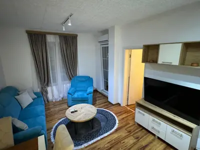 a living room with a blue couch and a table at VEMA 4 Apartments in Belgrade