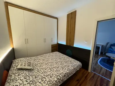 a small bedroom with a bed and a mirror at VEMA 4 Apartments in Belgrade
