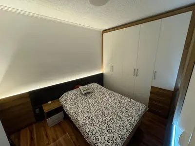 a small room with a bed and a cabinet at VEMA 4 Apartments in Belgrade